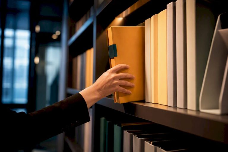 Hand lägger mapp i ett ordnat arkiv för personuppgifter